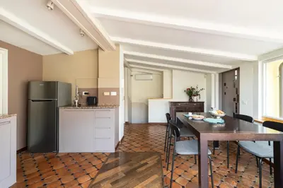 a kitchen and dining room with a table and a refrigerator at Trevi Charming Penthouse in Rome