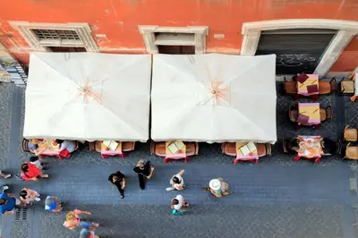 an overhead view of people sitting at tables with umbrellas at Trevi Charming Penthouse in Rome