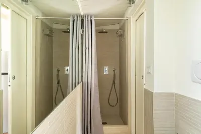 a walk in shower with a shower curtain in a bathroom at Trevi Charming Penthouse in Rome