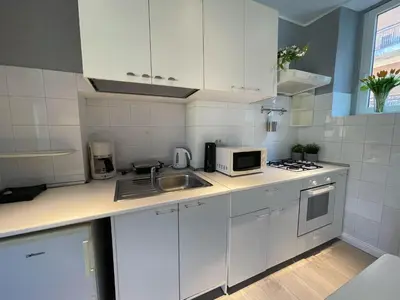 a white kitchen with a sink and a microwave at Vatican Holiday Apartment 317 in Rome