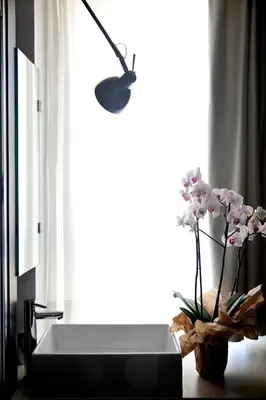 a vase of flowers sitting on a table next to a window at Sora Luxury Inn in Rome