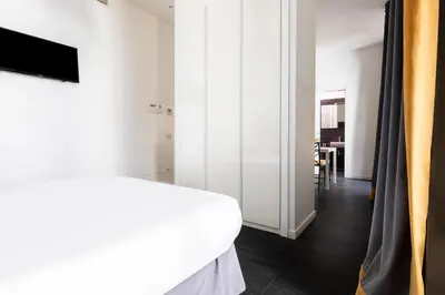 a bedroom with a white bed and a sliding glass door at Residenza Ottaviano 105 by Hili in Rome
