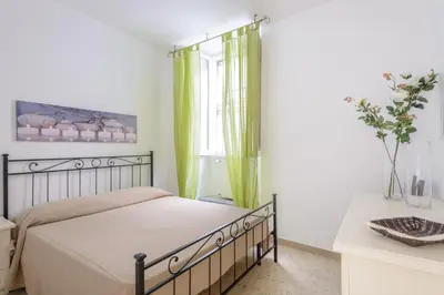 a bedroom with a bed and a window with green curtains at Appartamento Castel Sant'Angelo in Rome