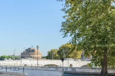 a bridge over a river with a building in the background at Appartamento Castel Sant'Angelo in Rome
