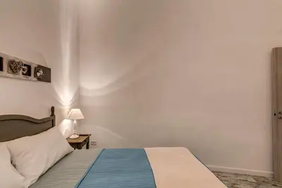 a bedroom with a bed and a table with a lamp at Loft in San Pietro in Rome