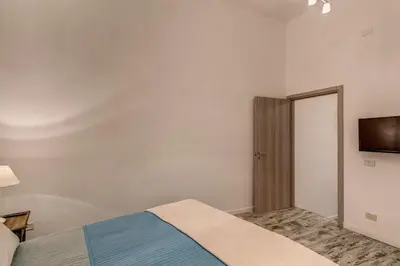 a bedroom with a bed and a flat screen tv at Loft in San Pietro in Rome