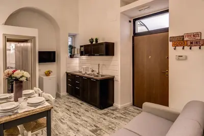 a living room with a couch and a table and a kitchen at Loft in San Pietro in Rome