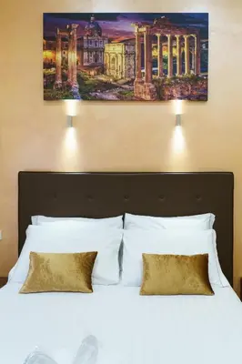 a bedroom with a bed and a desk and a television at Trinity Luxury Rooms in Rome