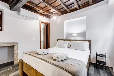 a bedroom with a white bed and a fireplace at Chiavari Apartment in Rome