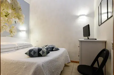 a bedroom with a bed with a television and a chair at Apartment Julia Guesthouse Trevi - Spagna in Rome