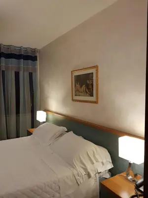 a bedroom with a white bed and two lamps at Apartment Julia Guesthouse Trevi - Spagna in Rome