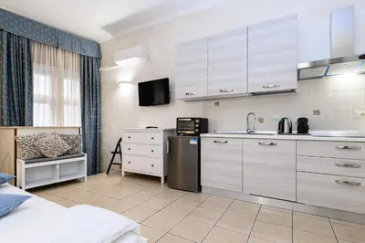 a kitchen with white cabinets and a sink in a room at Apartment Julia Guesthouse Trevi - Spagna in Rome