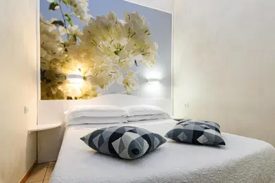 a bedroom with two pillows on a bed with a flower painting at Apartment Julia Guesthouse Trevi - Spagna in Rome