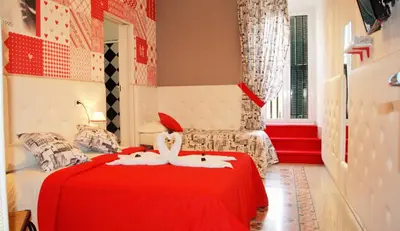 two white swans on a red bed in a room at I Love Piramide in Rome