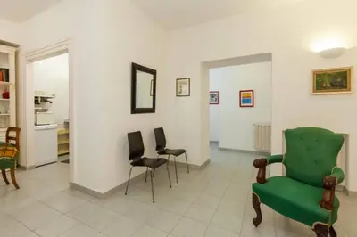 a living room with a green chair and chairs at Vatican Apartment in Rome