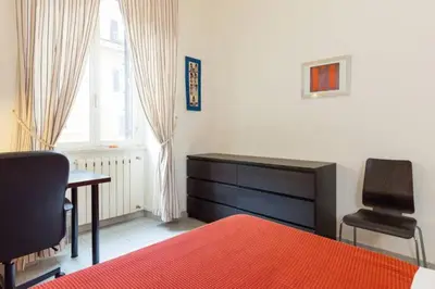 a bedroom with a bed and a desk and a chair at Vatican Apartment in Rome