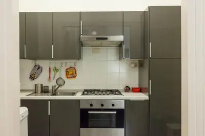 a kitchen with gray cabinets and a stove top oven at Vatican Apartment in Rome