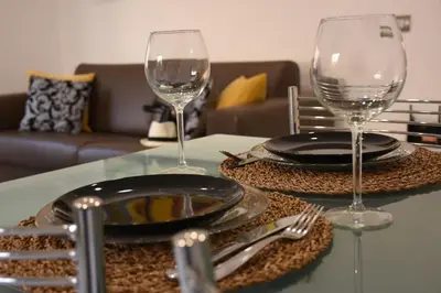 a table with two wine glasses and plates on it at Rampa Brancaleone Apartment in Rome