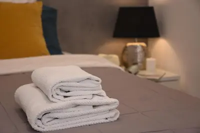 three towels stacked on a bed in a hotel room at Rampa Brancaleone Apartment in Rome