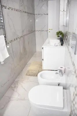 a white bathroom with a toilet and a sink at Rampa Brancaleone Apartment in Rome