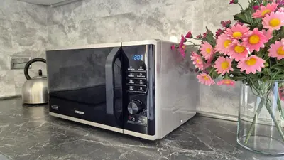 a microwave sitting on a counter next to a vase of flowers at Rampa Brancaleone Apartment in Rome