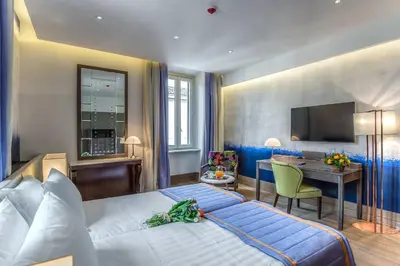 a hotel room with a large bed and a desk at Hotel Martis Palace in Rome