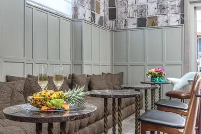 a living room with two tables with glasses of wine at Hotel Martis Palace in Rome