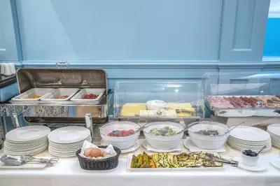 a buffet with plates and bowls of food on a table at Hotel Martis Palace in Rome
