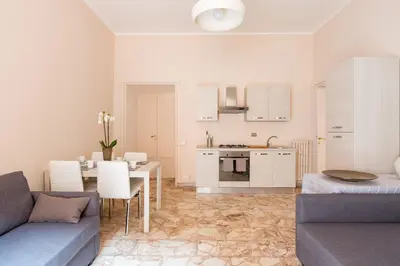 a kitchen and living room with a couch and a table at G-House Pettinari in Rome