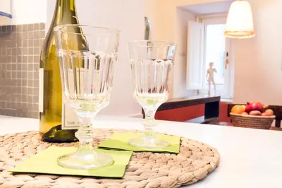 two wine glasses sitting on a table with a bottle of wine at Navona Stay Apartment in Rome