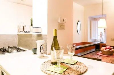 a bottle of wine and two glasses on a kitchen counter at Navona Stay Apartment in Rome