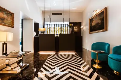 a lobby with two blue chairs and a table at Hotel 87 eighty-seven - Maison d'Art Collection in Rome