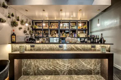 a bar with a marble counter and bottles of alcohol at Hotel 87 eighty-seven - Maison d'Art Collection in Rome