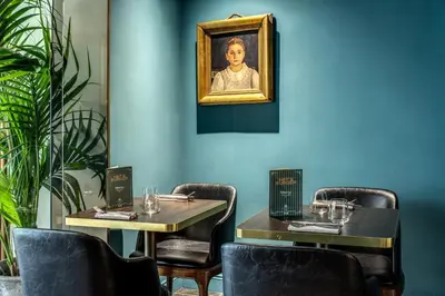 a dining room with two tables and a painting of a woman at Hotel 87 eighty-seven - Maison d'Art Collection in Rome