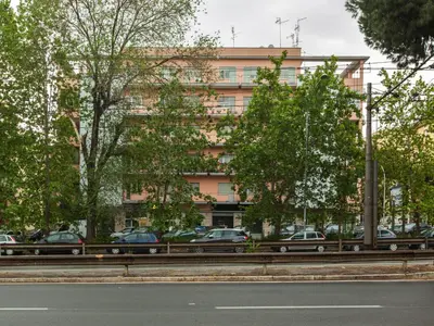 a building with cars parked in front of a street at Anice Guesthouse in Rome