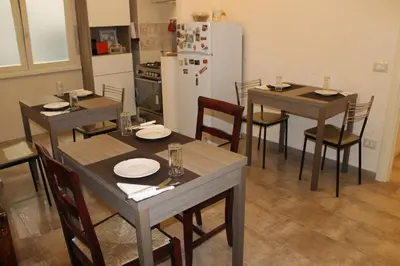 a dining room with tables and chairs and a refrigerator at Anice Guesthouse in Rome