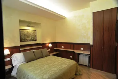 a bedroom with a bed and wooden cabinets at Residenza Matteucci in Rome