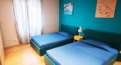 two beds in a bedroom with blue walls at Casa Santarelli in Rome