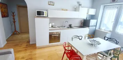 a kitchen with white cabinets and a table with chairs at Casa Santarelli in Rome