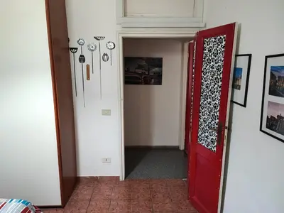a hallway with a red door and some pictures at Turati House in Rome