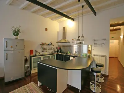a large kitchen with a table and a refrigerator at Casa Leopardo - Trastevere in Rome