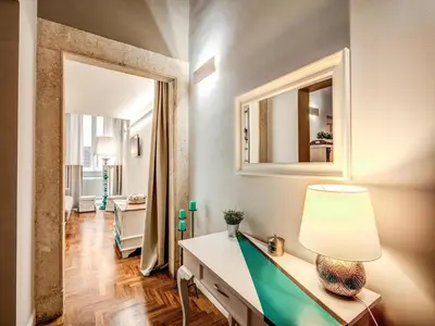 a room with a table with a lamp and a mirror at Residenza Paola - 2BR Trastevere in Rome