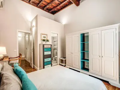 a bedroom with a large bed and a dresser at Residenza Paola - 2BR Trastevere in Rome