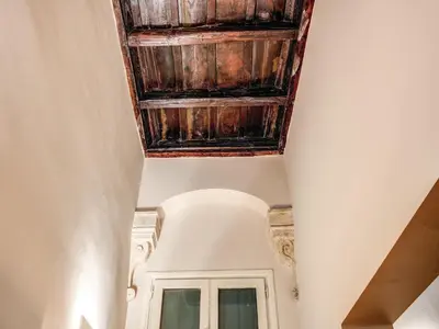 a ceiling with wooden beams in a hallway at Residenza Paola - 2BR Trastevere in Rome