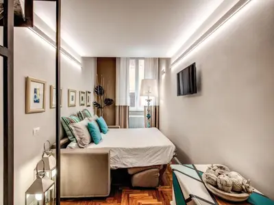a small room with a bed and a mirror at Residenza Paola - 2BR Trastevere in Rome