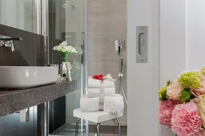 a bathroom with a sink and a chair and flowers at Vatican Style in Rome