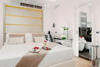 a bedroom with a large white bed with a tray on it at Vatican Style in Rome