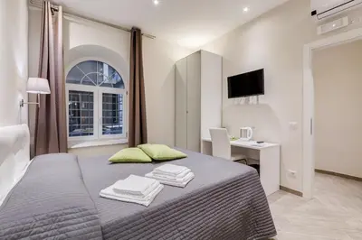 a bedroom with a bed and a desk and a television at Vaticano 38 Suites in Rome