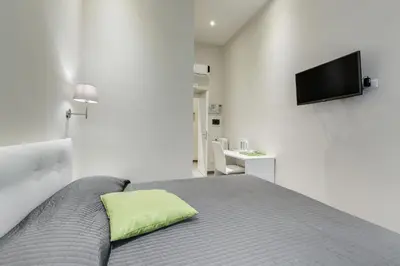 a bedroom with a bed with a green pillow on it at Vaticano 38 Suites in Rome