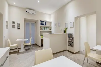a room with white walls and a table and chairs at Vaticano 38 Suites in Rome